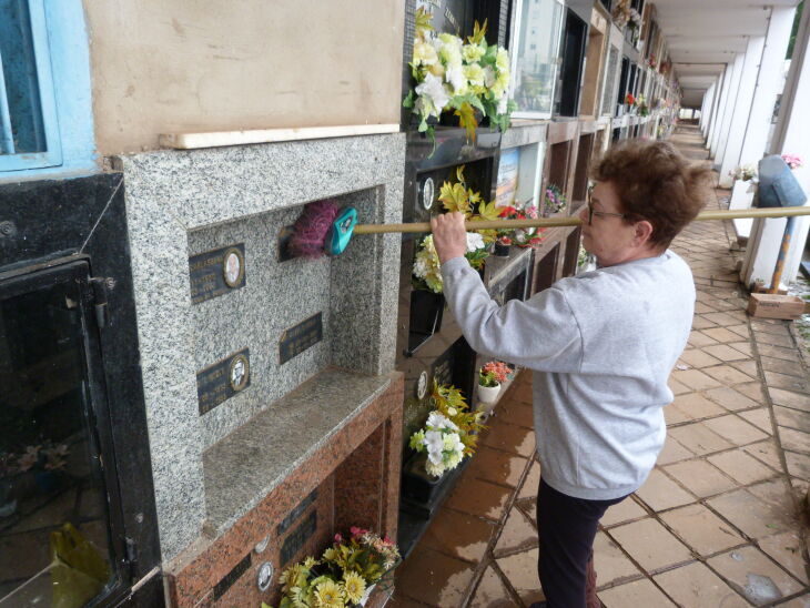 Ione Couto, 70 anos, aproveitou a trégua da chuva para limpar o túmulo de familiares. Foto: Gerson Lopes/ON