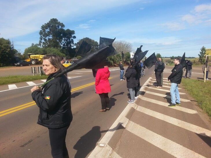 Os manifestantes carregavam bandeiras pretas para lembrar as vítimas de acidentes na rodovia