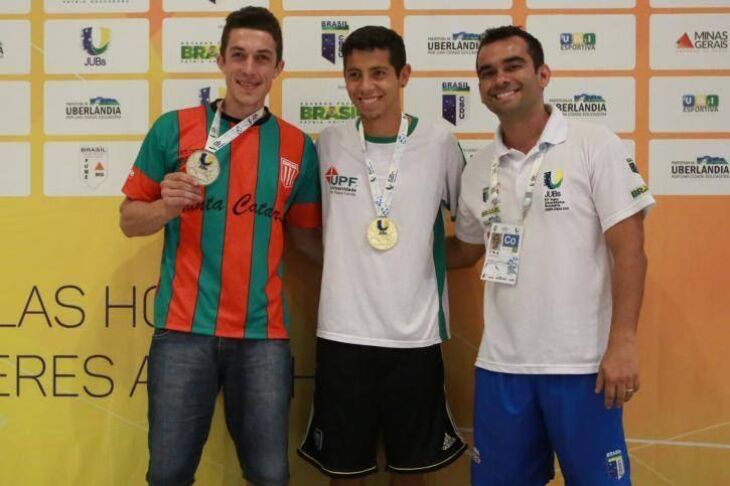 Ao centro, atleta exibe medalha