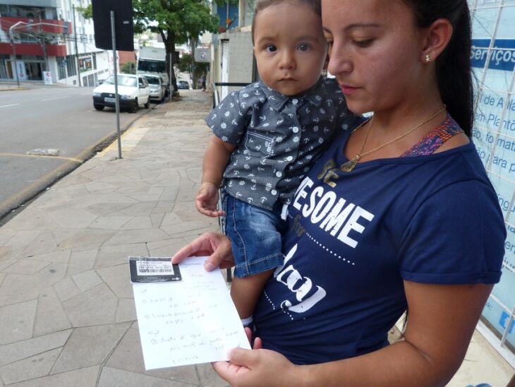 Clarissa Lucas Polig pega vitamina e pomada antialérgica para o filho Enzo na Farmácia Central