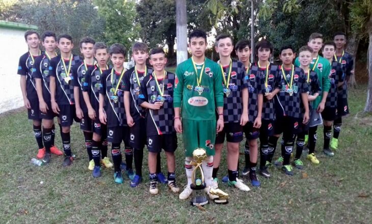 Atletas com as medalhas no peito e o troféu de vencedor