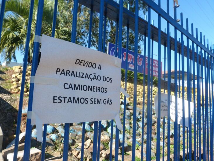 Cartaz no portão de entrada alerta consumidores sobre a falta do produto