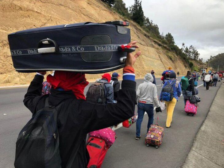 Venezuelanos caminham por estrada equatoriana a caminho do Peru